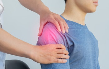 Practitioner performing Bowen Therapy on patient's shoulder