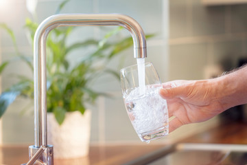 Filling a water glass with the faucet.