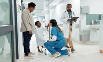 Nurse crouched down talking to pediatric patient