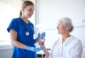 Nurse holding medications and glass of water for an elderly patient 