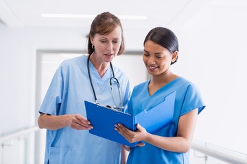  two nurses collaborating over a patient's chart. 