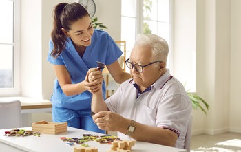 Nurse assisting a dementia resident with a puzzle.