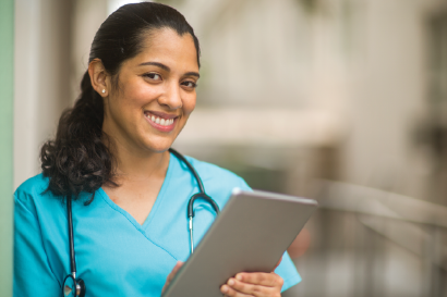 Nurse with tablet smiling at camera