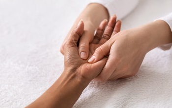 Professional massaging client's hand