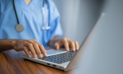 Male nurse typing on laptop computer