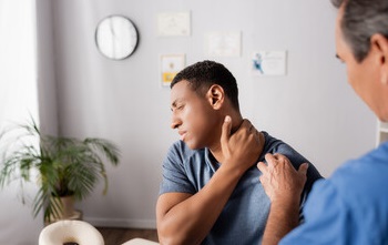 Doctor evaluating a patient's neck pain.