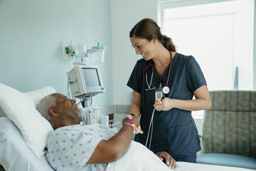 nurse speaking to patient in hospital bed