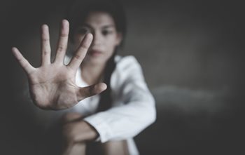 Human trafficking victim holding hand up