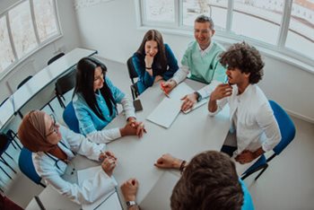 Group of healthcare professionals sitting at a conference table. 