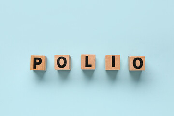 Wood block spelling POLIO against a blue background