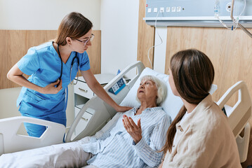 Nurse talking to elderly hospital patient