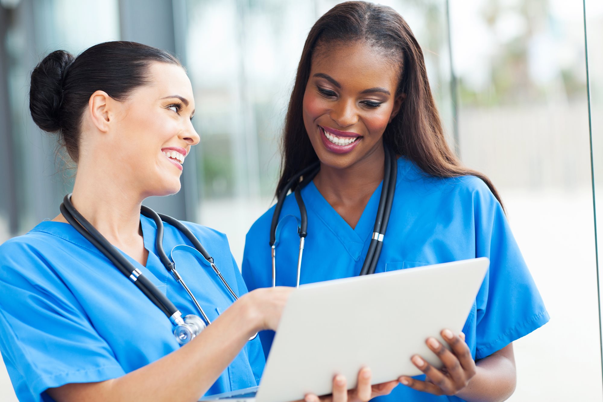 Two nurses looking at tablet doing CE