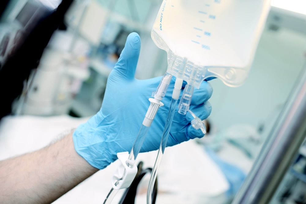 Male nurse hanging IV bag.