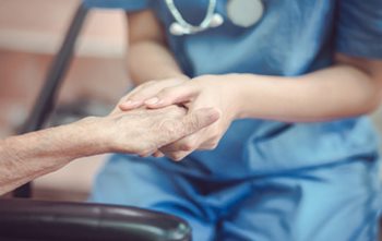 nurse holding a elderly persons hand. 