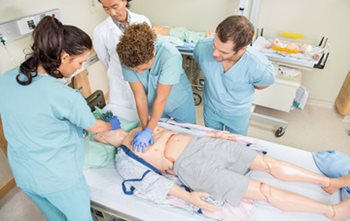 Nurses practicing CPR on a dummy patient.