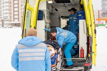 Paramedics loading patient into ambulance in the snow