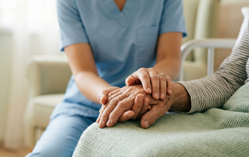 Nurse with elderly patient holding hand
