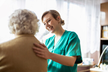 nurse supporting a elderly woman in LTC