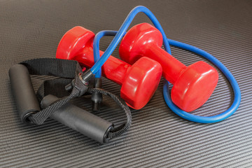 bright red exercise dumbbells and blue exercise band.