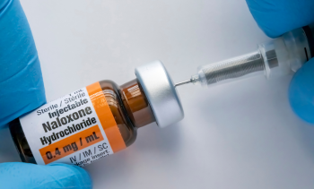 Nurse withdrawing from a bottle of Naloxone