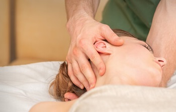 massage being performed on womans neck for headache