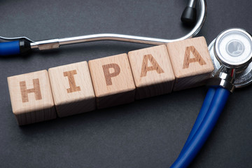 Stethoscope around wooden blocks spelling out HIPAA