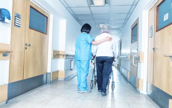 Nurse helping patient ambulate with a walker