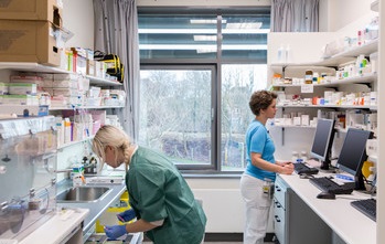 2 nurses working in a long term care medication room. 